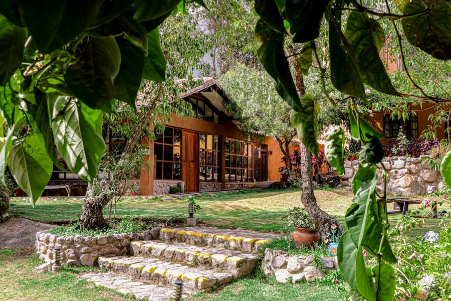 Casa vidriada vista entre el follaje del jardín