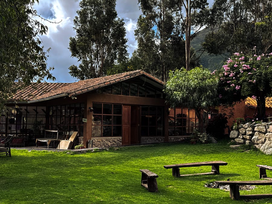 Casa vidriada y jardín con bancas de madera